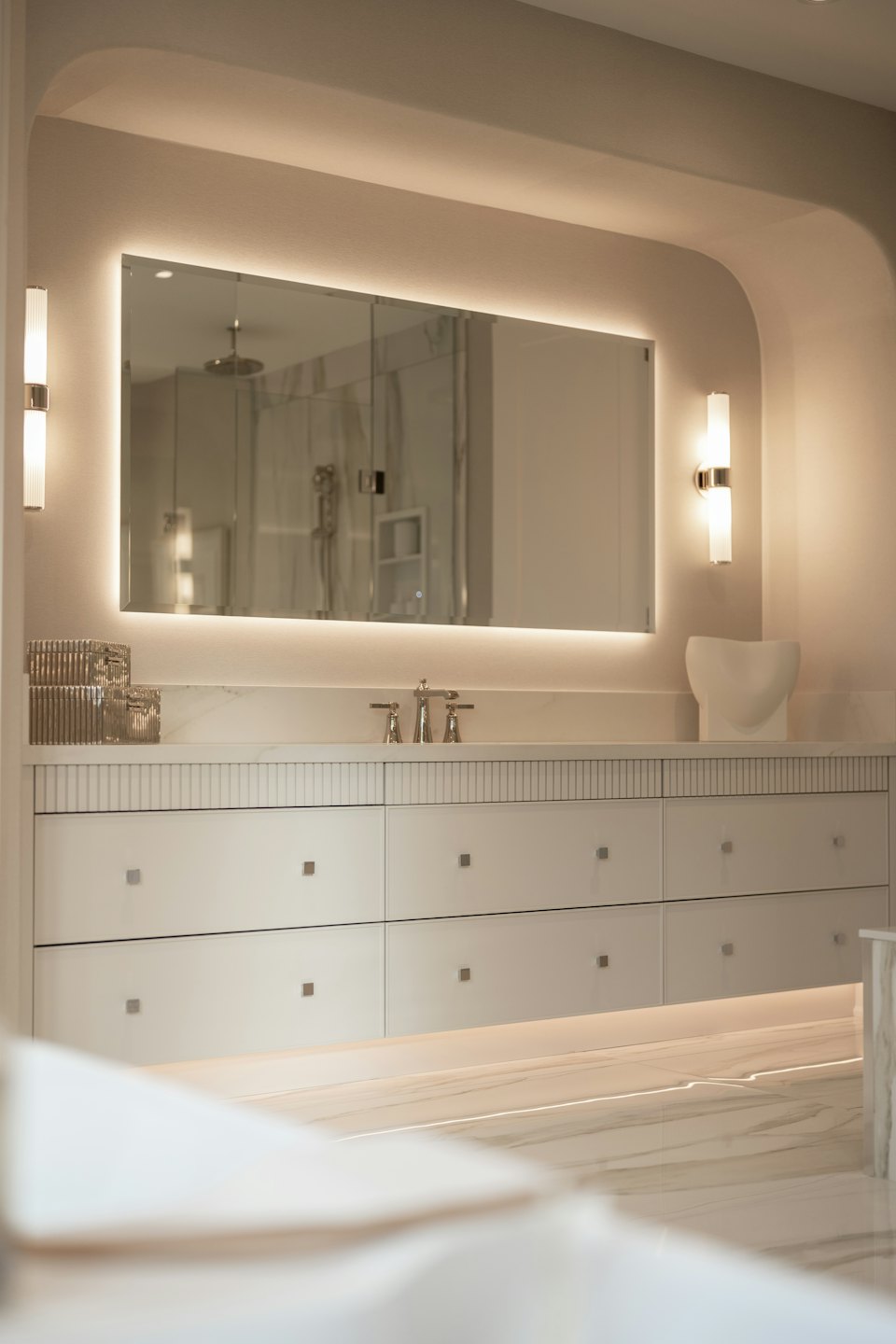 Marble bathroom vanity with a mirror and modern fixtures.