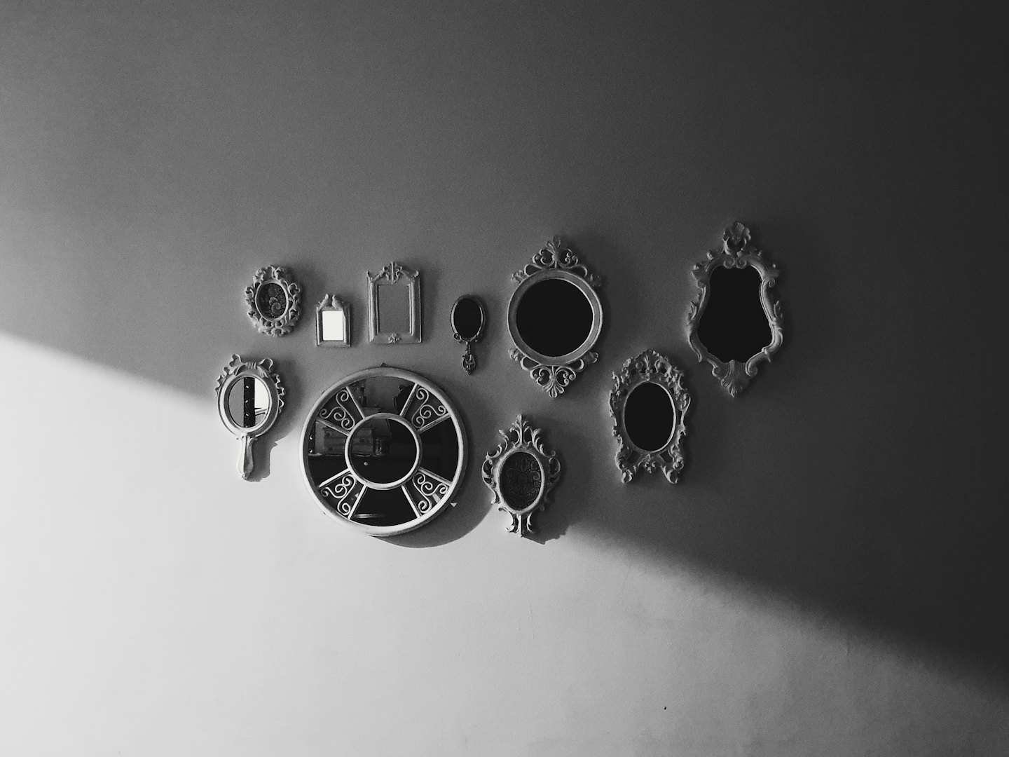 Collection of ornate vintage mirrors on an indoor wall.